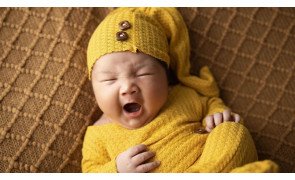 bebe com sono de roupa amarela