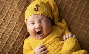 bebe com sono de roupa amarela